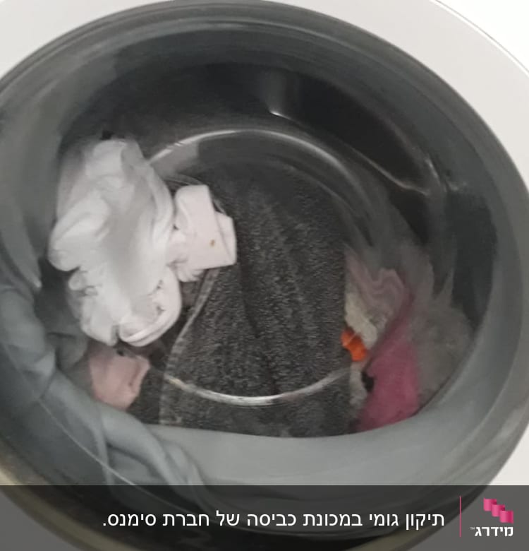 מכונת כביסה עם בגדים בתוף הכביסה